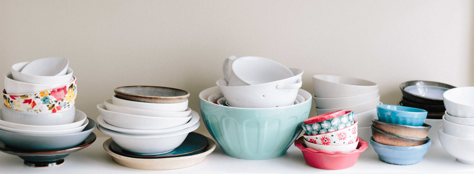 image of stacked melamine items like bowls and plates on a shelf posing a the question is melamine microwave safe for human health and how does heat affect melamine exposure levels