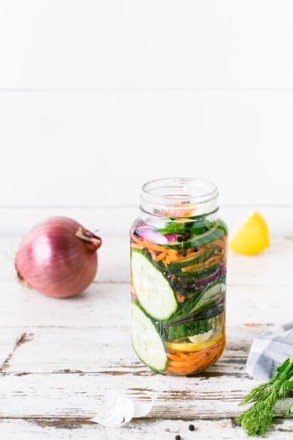 jar of fermented veggies, onion and lemon on table