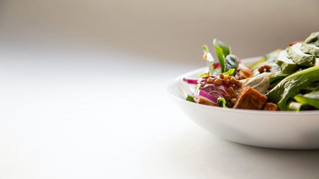 salad in a white bowl against white background