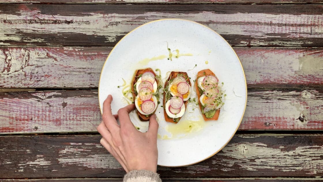 sweet potato toast with egg radish and a hand reaching in