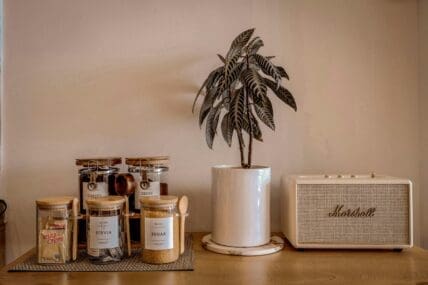 Image of a kitchen counter with little glass jars of sugar, stevia, coffee, and creamer.