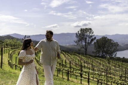 Image of an attractive couple standing in front of the vineyards at the Four Seasons Resort Napa Valley.