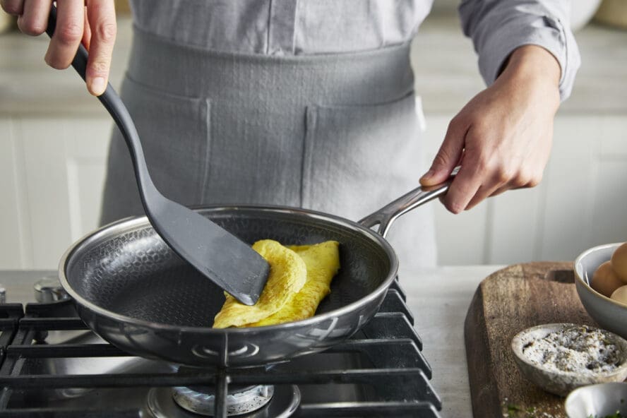 Image of someone flipping an omelette with a spatula in a GreenPan Spectra frypan.